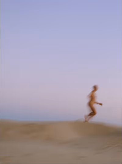 Dreamy blurry photo of a person running on a beach, evoking movement, breaking free, and ongoing cycles.