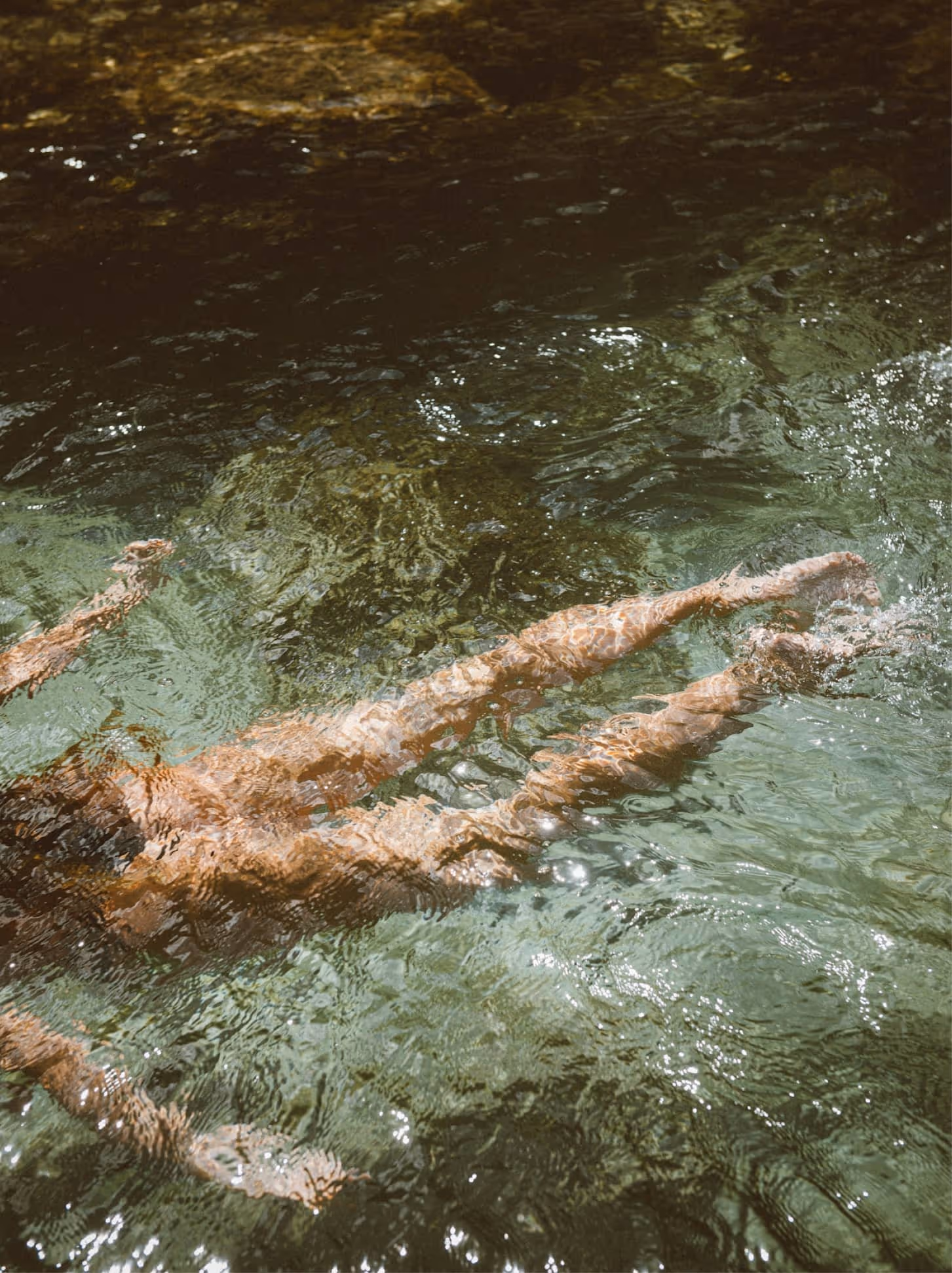 Woman swimming underwater in bright light, conveying freedom, relief, and the clarity that comes with diagnosis.